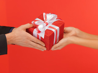 man and woman's hands with gift box
