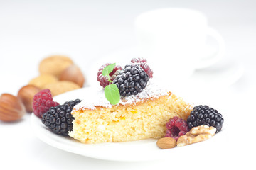 cup, cake, raspberry, blackberry,nuts and mint on a plate on a w