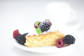 cup, cake, raspberry, blackberry,nuts and mint on a plate on a w