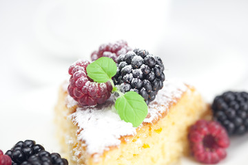 cup, cake, raspberry, blackberry,nuts and mint on a plate on a w