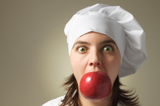 Chef with an apple in her mouth