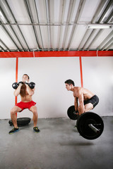 Fototapeta na wymiar Grupa dwóch osób przy wykonywaniu sztangi w siłowni i kettleb