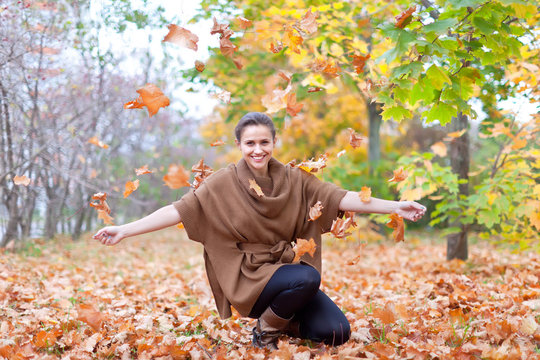 Woman throws autumn leaves