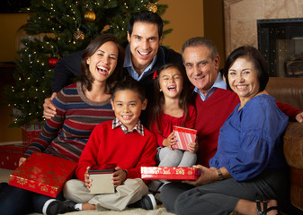 Multi Generation Family In Front Of Christmas Tree