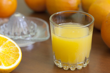 Orange fresh juice with squeezer on table