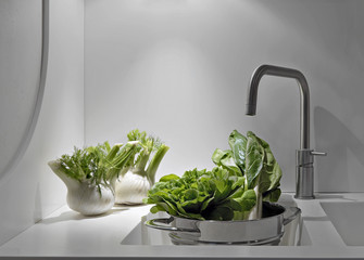 ortaggi sul piano e nel lavandino della cucina moderna