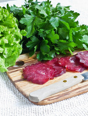 Tasty  chopped sausage on wooden board