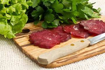Tasty chopped  sausage on wooden board