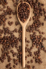 Coffee beans and wooden spoon on burlap.