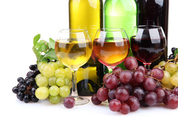 bottles and glasses of wine and assortment of grapes, isolated