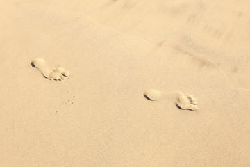 Fototapeta na wymiar human footsteps at the clean sandy beach