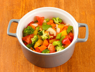 Vegetable stew in gray pot on wooden background