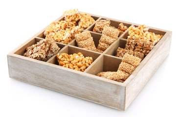 tasty sweets (kozinaki)in wooden crate, isolated on white