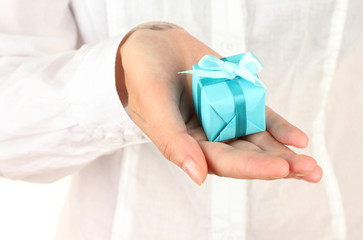 woman holds a box with a gift on white background close-up