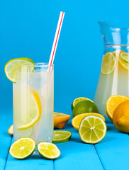 Citrus lemonade in pitcher and glass of citrus around