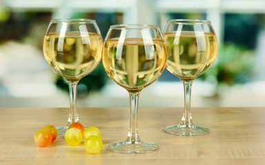 White wine in glass on window background