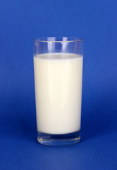 Glass of fresh new milk on blue background