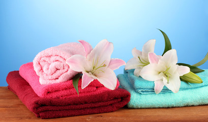 Fototapeta na wymiar stos ręczników różowy lilia na niebieskim tle.