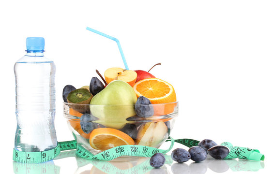 Glass bowl with fruit for diet, measuring tape and water bottle