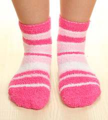 Legs female in striped socks on laminate floor