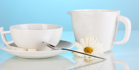 A cup of strong coffee and sweet cream on blue background