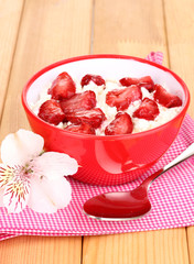 Cottage cheese in red bowl with sliced strawberries