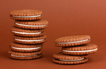 Chocolate cookies with creamy layer on brown background