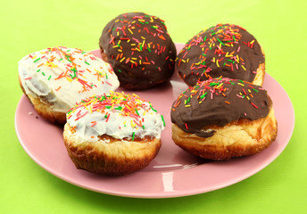 Tasty donuts on color plate on color background