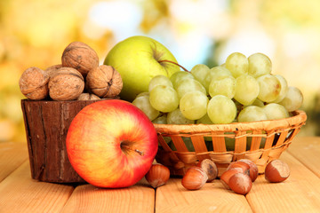 Grape in basket with nuts on wooden table