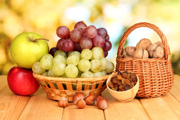 Grape in basket with nuts on wooden table