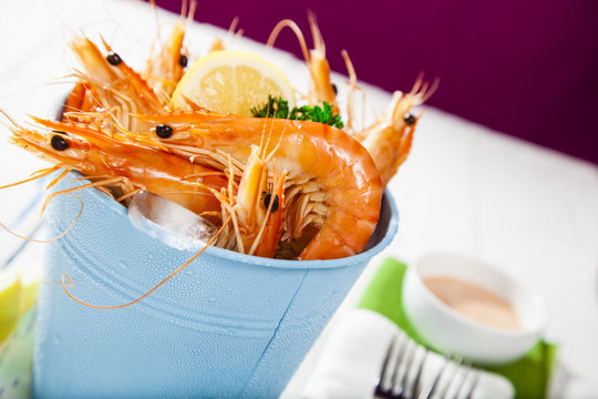 Bucket of king prawns on ice