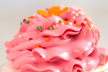 pink cream and topping on cupcake