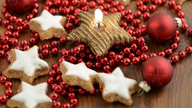 Weihnachten. Kerze mit Zimtsternen und Weihnachtskugeln