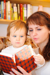 Mother with her little baby son reading book