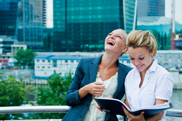 Fototapeta premium Two young and beautiful business women discussing a business pro