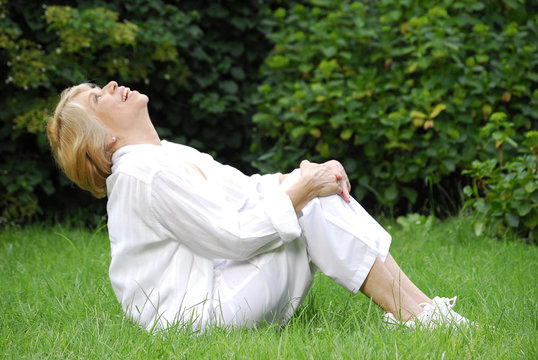 Se&ntilde;ora feliz haciendo ejercicios en un jard&iacute;n.relajada