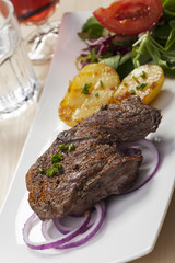 Steak mit Kartoffelhälften und Salat