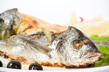 Fried fish garnished on sliced olive and sauce