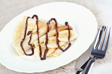 Thin pancakes with banana and chocolate