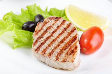 Grilled steak on white plate closeup