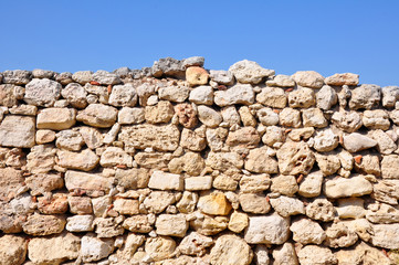 Old stone wall on a blue sky
