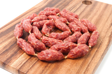 A heap of mini Salamis on wooden board