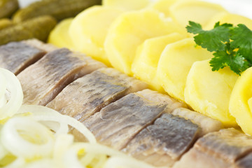 Portion of herring fish fillets with potato and onion