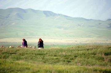 Rolgordijnen Two ladies in national dress walking in the green hills of Turkmenistan near the Iranian border. © berimitsu