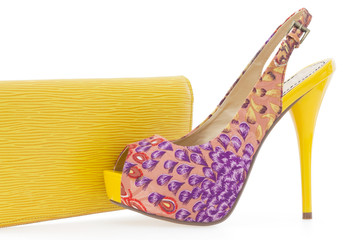Yellow women stiletto shoe with matching bag, isolated on white