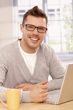 Handsome guy using laptop smiling