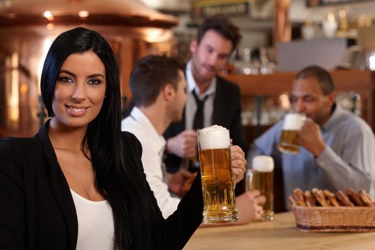 Young woman in pub with mug of beer