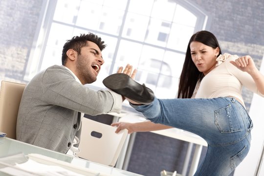 Young woman kicking boyfriend