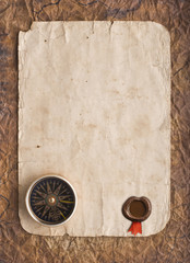 Fototapeta na wymiar old compass on grunge background with a wax seal and ribbon