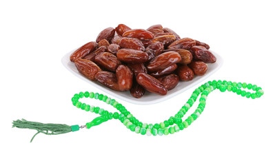 dates on white plate with Islamic rosary isolated on white